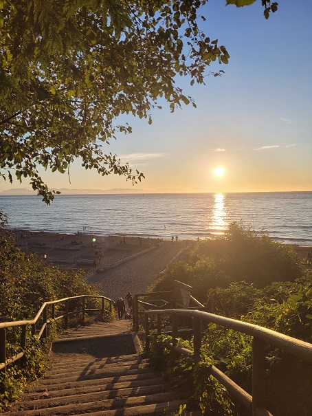 ## Sunset Serenade: Wreck Beach's Evening Splendor
The sunset of Wreck Beach is always so splendid. It’s only 5 min from my dorm: Saint John’s College. We have to go down about 460 stairs to the beach which can be quite an exercise for the newcomers. Once you get there, you can see this breathtaking scenery every evening especially when it’s not raining. In the summer, there are so many people and students watching the sunset. A convention here is to howl like a wolf when the sun disappears: AWWOOOOO!